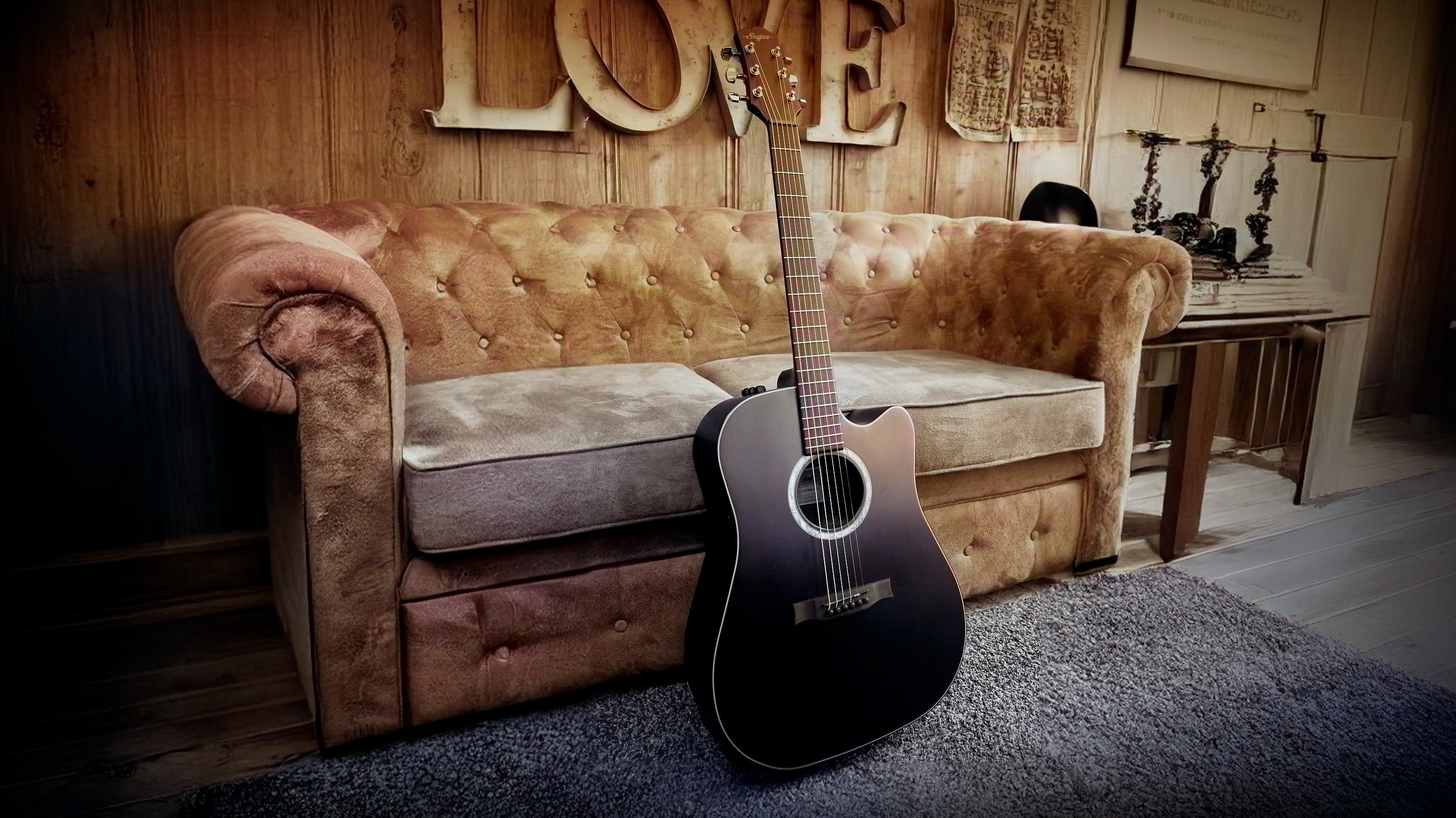 Stanford acoustic guitar leaning against couch